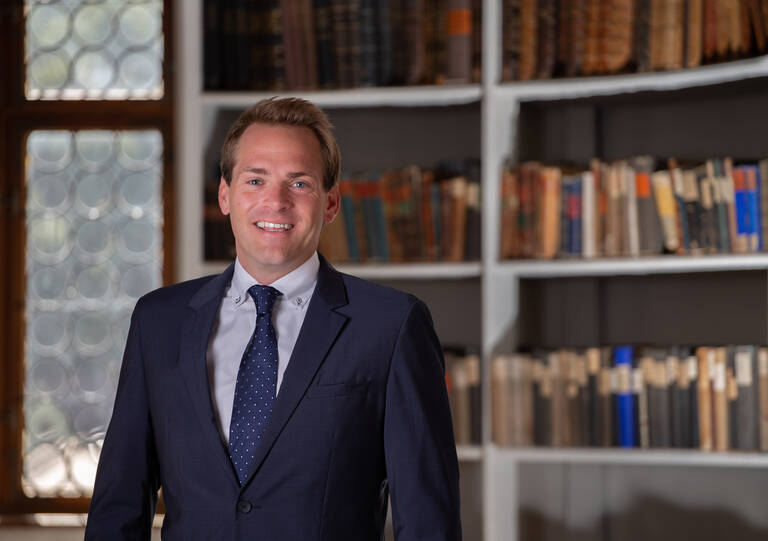 Portrait des Ersten Bürgermeisters. Im Hintergrund ist verschwommen die Klosterbibliothek zu sehen